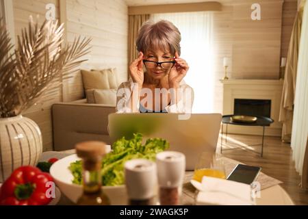 Die alte Dame arbeitet fernab in ihrer Küche Stockfoto