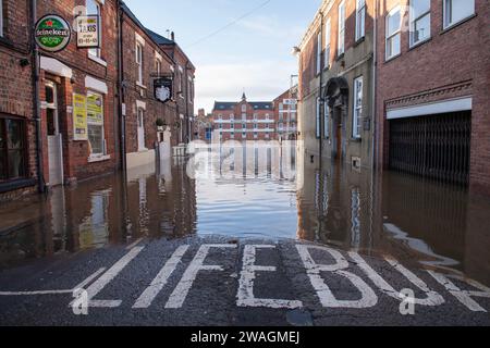 Überschwemmung im Stadtzentrum von York am 4. Januar 2024 auf der Cumberland Street mit Woodsmill Quay Apartments, die sich im Wasser spiegeln Stockfoto