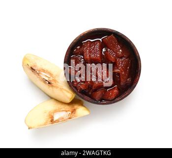 Schüssel mit süßer Marmelade und Quittenfruchtescheiben auf weißem Hintergrund Stockfoto