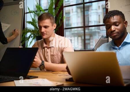 Männer, die an Laptops arbeiten, sitzen im Büro, besuchen Schulungskurse Stockfoto