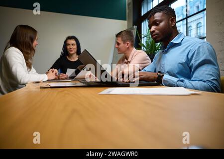 Multiethnische Kollegen Anwälte sitzen im gemütlichen Büro mit Laptops Stockfoto