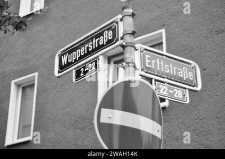 Graue Aufnahme von Straßenschildern, die die Kreuzung von Wupperstraße und Erftstraße anzeigen Stockfoto