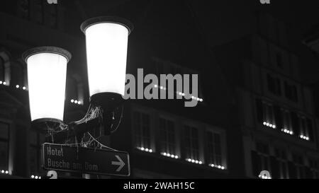 Graustufenaufnahme einer alten Straßenlaterne in der eisigen Nacht in Münster Stockfoto