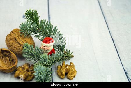 Walnüsse, Tannenzweig und Weihnachtsfigur, symbolisches Weihnachtsbild Stockfoto