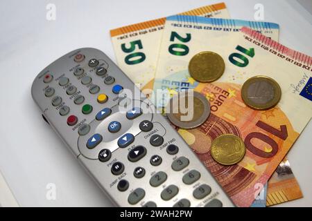 Fernbedienung und Geld, Symbolbild des Pay-TV Stockfoto