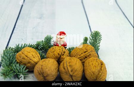 Walnüsse, Tannenzweig und Weihnachtsfigur, symbolisches Weihnachtsbild Stockfoto