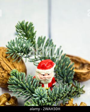 Walnüsse, Tannenzweig und Weihnachtsfigur, symbolisches Weihnachtsbild Stockfoto