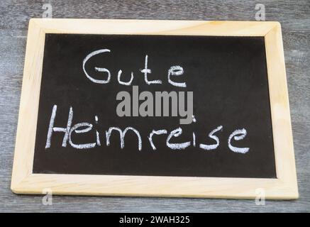 Schwarze Tafel mit der Aufschrift „Gute Heimreise“ am Ende einer Präsentation Stockfoto