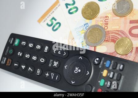 Fernbedienung und Geld, Symbolbild des Pay-TV Stockfoto