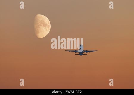 Flugzeug im Flug mit einem wachsenden Mond im Hintergrund, Deutschland, Bayern, Flughafen München Stockfoto