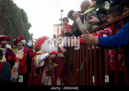 Malaga, Spanien. Januar 2024. Ein als Melchior gekleideter Mann, der einen der drei Weisen darstellt, wird während der traditionellen Epiphanienparade im Bezirk Cruz de Humilladero gesehen, wie er Kinder begrüßt. Die Viertel von Malaga feiern die traditionellen Epiphany-Paraden in der Stadt, indem sie Süßigkeiten werfen oder Kindern Geschenke schenken, in Anwesenheit von Tausenden von Menschen. Quelle: SOPA Images Limited/Alamy Live News Stockfoto