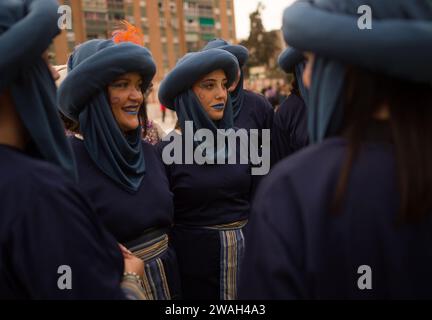 Malaga, Spanien. Januar 2024. Frauen in schwarzen Kostümen wurden vor der traditionellen Epiphany-Parade im Bezirk Cruz de Humilladero beim Gespräch gesehen. Die Viertel von Malaga feiern die traditionellen Epiphany-Paraden in der Stadt, indem sie Süßigkeiten werfen oder Kindern Geschenke schenken, in Anwesenheit von Tausenden von Menschen. Quelle: SOPA Images Limited/Alamy Live News Stockfoto