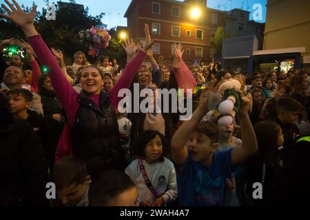 Malaga, Spanien. Januar 2024. Während der traditionellen Epiphany-Parade im Viertel Cruz de Humilladero werden Menschen nach Süßigkeiten und Geschenken gefragt. Die Viertel von Malaga feiern die traditionellen Epiphany-Paraden in der Stadt, indem sie Süßigkeiten werfen oder Kindern Geschenke schenken, in Anwesenheit von Tausenden von Menschen. Quelle: SOPA Images Limited/Alamy Live News Stockfoto