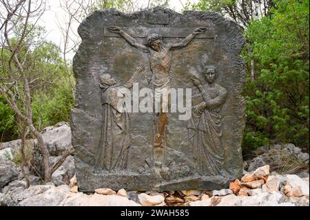 Die Kreuzigung Jesu – das fünfte schmerzhafte Geheimnis des Rosenkranzes. Eine Reliefskulptur auf dem Berg Podbrdo (der Hügel der Erscheinungen) in Medjugorje. Stockfoto