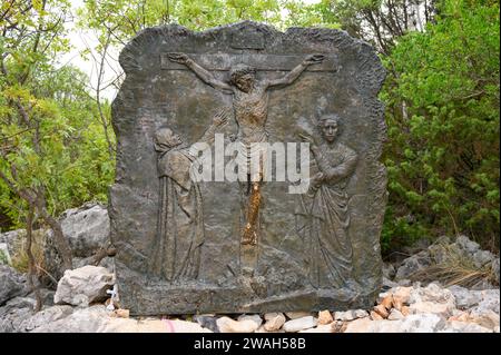 Die Kreuzigung Jesu – das fünfte schmerzhafte Geheimnis des Rosenkranzes. Eine Reliefskulptur auf dem Berg Podbrdo (der Hügel der Erscheinungen) in Medjugorje. Stockfoto