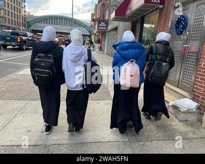 Studentinnen gehen auf der 4th Avenue von einer privaten islamischen High School nach Hause, die sie in Brooklyn, New York besuchen. Stockfoto