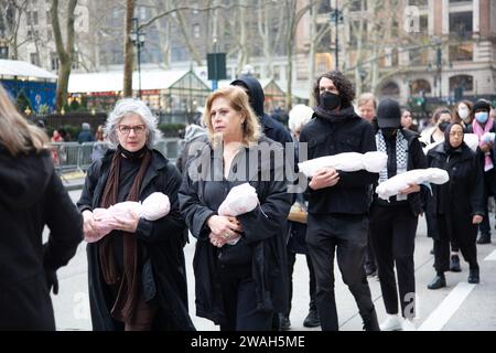 Stumme Mahnwache mit Menschen, die Babys in den Armen halten, während sie in Manhattan marschieren, und uns daran erinnern, die Spaltungen zu überwinden und wieder menschlich zu werden und beide Seiten der israelischen Hamas den Wahnsinn zu stoppen. Initiiert von jüdischen Ältesten und Alliierten für die Waffenruhe. Stockfoto