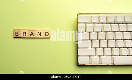 Nahansicht eines Holzwürfels mit Markenwort und Computertastatur. Konzept der Branding-Strategie Stockfoto