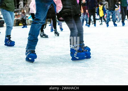 Menschen, die auf Schlittschuhen in der Eislaufarena in der Stadt stehen und das kalte Wetter im Winter genießen Stockfoto