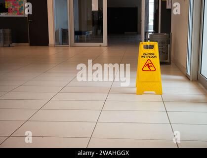 Achtung: Schild mit nassem Boden auf einer Halle Stockfoto