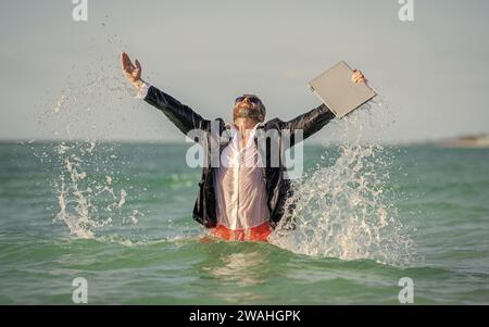 Geschäftsmann, aufgeregt im Meerwasser. Geschäftsmann im Taucheranzug im Meerwasser. Verrückter Geschäftsurlaub. Ein erfolgreicher Geschäftsmann, der sich endlich erholt hat. Geschäftsmann Stockfoto