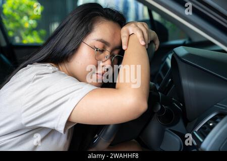 Junge Asiaten fühlen sich beim Fahren schläfrig Stockfoto