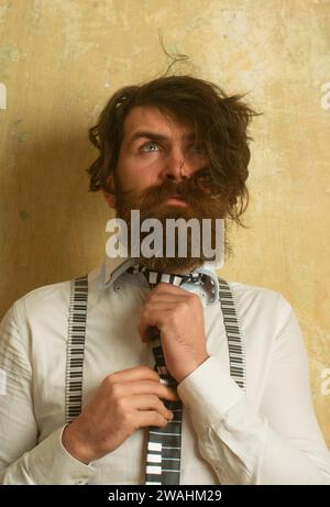 Porträt eines lustigen Hipster-Mannes. Porträt von lustigen bärtigen Mann in weißem Hemd binden die Krawatte. Bärtiger Mann mit ungekämmtem zerhaartem Haar. Verrückt Stockfoto
