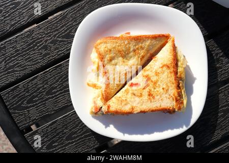 Sandwich mit Masala-Brot und Omelette im Straßenstil. Frisch gekochte Eier mit Zwiebeln, Tomaten und Gewürzen. Kopierbereich. Gesunde Frühstücksideen. Stockfoto