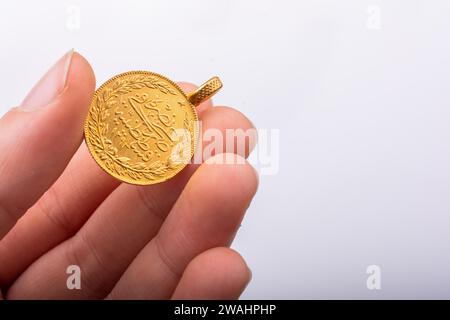 Türkischen osmanischen Stil Gold Münze in der Hand auf weißem Hintergrund Stockfoto