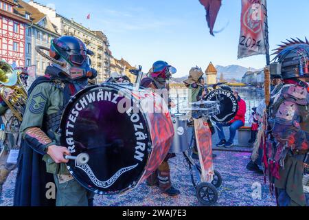 Luzern, Schweiz - 21. Februar 2023: Band von Musikern in Kostümen marschieren durch die Straßen, und Publikum, Teil des Fasnacht Karnevals, in Luzern (Lu Stockfoto