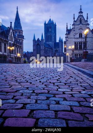 Die Dämmerung führt über die Kopfsteinpflasterstraßen von Gent, mit der majestätischen St. Bavo's Cathedral hoch im Hintergrund Stockfoto