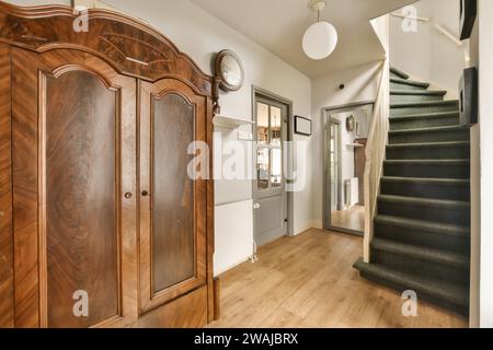 Eingangskorridor mit Pendelleuchte über Holzschrank und Treppe eines modernen Hauses Stockfoto