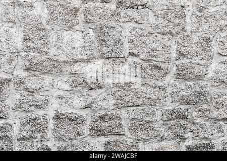 Alter hellgrauer Steinmauerhintergrund. Vorderansicht der Steinwand in Großansicht Stockfoto