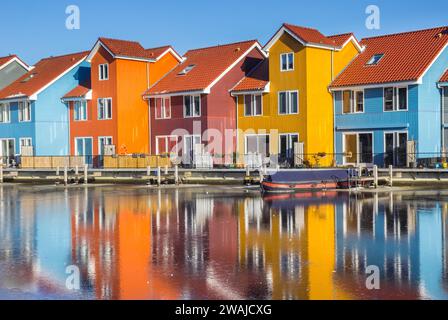 Bunte Häuser spiegeln sich im gefrorenen See in Groningen, Niederlande Stockfoto