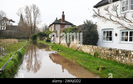 Alfriston, Sussex UK 5. Januar 2024 - Häuser pumpen Wasser weg, da sie vom Hochwasser des Cuckmere River in Alfriston, East Sussex umgeben sind, nach einer weiteren Nacht mit starkem Regen mit über 300 Hochwasser- und Wetterwarnungen im ganzen Land: Credit Simon Dack / Alamy Live News Stockfoto