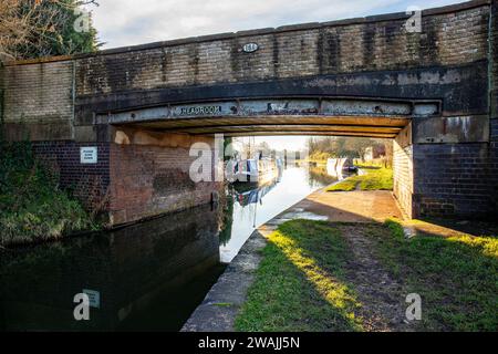 Brücke 161 über Trent und Mersey Canal mit vertäuten schmalen Booten in Cheshire UK Stockfoto