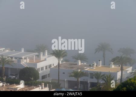 AGUADULCE, SPANIEN - 12. DEZEMBER 2023 Nebel hängt über einer Küstenstadt in Spanien, Blick auf die Promenade, den Küstenstreifen und das Mittelmeer in der Andalu Stockfoto