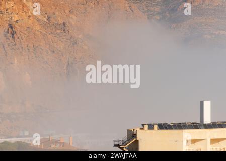 AGUADULCE, SPANIEN - 12. DEZEMBER 2023 Nebel hängt über einer Küstenstadt in Spanien, Blick auf die Promenade, den Küstenstreifen und das Mittelmeer in der Andalu Stockfoto