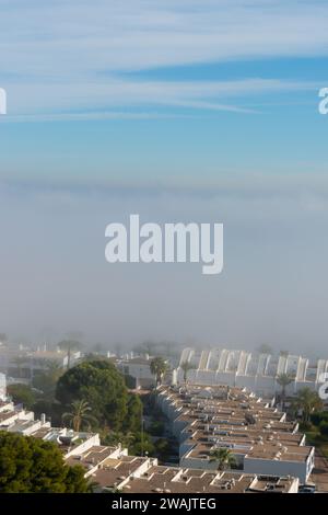 AGUADULCE, SPANIEN - 12. DEZEMBER 2023 Nebel hängt über einer Küstenstadt in Spanien, Blick auf die Promenade, den Küstenstreifen und das Mittelmeer in der Andalu Stockfoto
