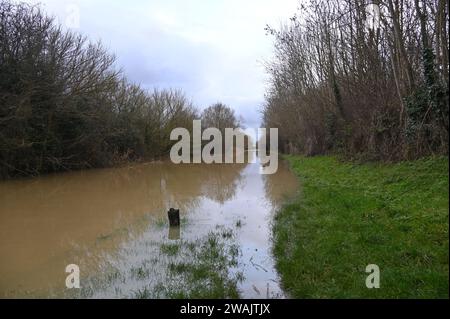 Nach starkem Regen platzte der Oxford Canal über seine Ufer und überflutete angrenzende Felder. Dieses Bild wurde auf dem Schleppweg in der Nähe der Nell Bridge in Oxfordshire aufgenommen Stockfoto