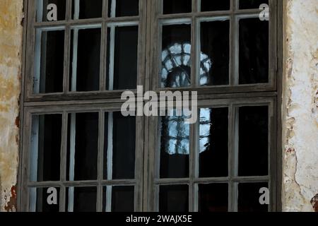 Ein altes Fenster, das durch ein anderes Fenster gesehen wird Stockfoto