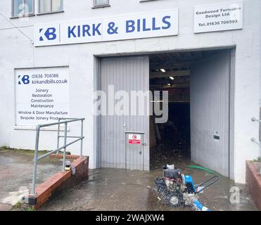 Hochwasser wird außerhalb von Kirk and Bill's gepumpt, einer Möbelwerkstatt in Newark-on-Trent, Nottinghamshire. Wasser ist durch die Dielen und Abflüsse aufgrund der Überschwemmung durch Sturm Henk gestiegen, die die Werkstatt überschwemmt hat. Bilddatum: Freitag, 5. Januar 2024. Stockfoto