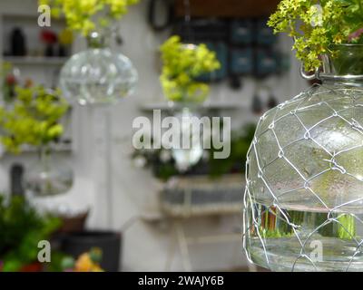 Ein auf Pflanzen spezialisiertes Einzelhandelsgeschäft bietet farbenfrohe Blumenarrangements in hohen Vasen Stockfoto