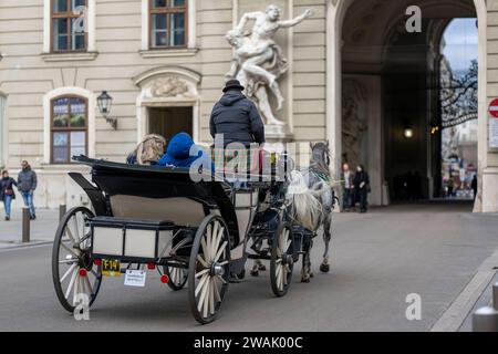 21.11.2023, Österreich, die Hauptstadt Wien. Impressionen an der Hofburg, eine Kutsche Fiaker kutschiert Besucher durch die Stadt. 21.11.2023, Wien in Österreich 21.11.2023, Wien in Österreich *** 21 11 2023, Österreich, die Hauptstadt Wien Impressionen an der Hofburg führt eine Pferdekutsche die Besucher durch die Stadt 21 11 2023, Wien in Österreich 21 11 2023, Wien in Österreich Stockfoto