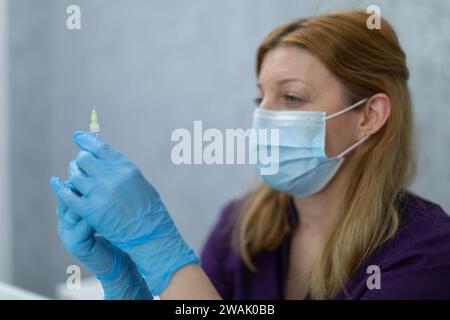 Nahaufnahme der Figur einer Krankenschwester, die eine Spritze Medizin in der Hand hält. Stockfoto