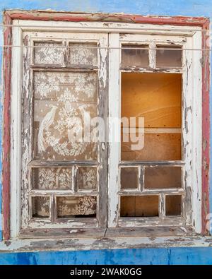 Eine Nahaufnahme eines alten Holzfensters mit verblasster Farbe Stockfoto