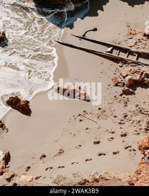 Ein Blick aus der Vogelperspektive auf das ruhige Meer und die Spuren im Sand am Strand Cala Saladeta, Ibiza, Spanien Stockfoto