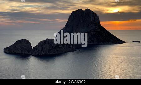 Ein Blick aus der Luft auf den romantischen Sonnenuntergang über dem Meer und einen Felsen in es Vedra, Ibiza, Spanien Stockfoto