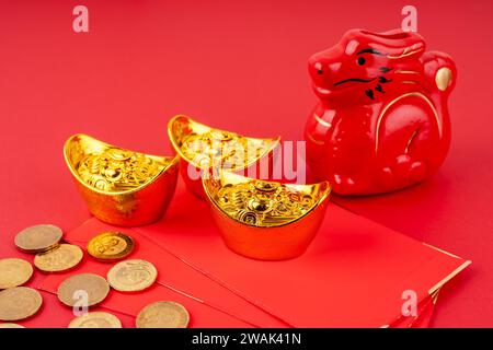 Jahr des Drachen mit rotem Umschlag und Goldbarren und Münzen Stockfoto