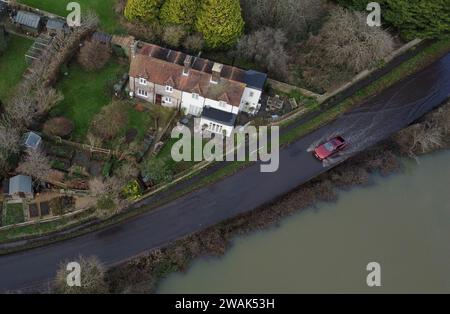 Ein Auto fährt durch das Hochwasser des Cuckmere River in Alfriston, East Sussex. Die Auswirkungen von Oberflächenwasser- und Flusspflutungen werden in Teilen Englands nach starken Regenfällen weiterhin „erheblich“ sein, warnten Experten. Bilddatum: Freitag, 5. Januar 2024. Stockfoto